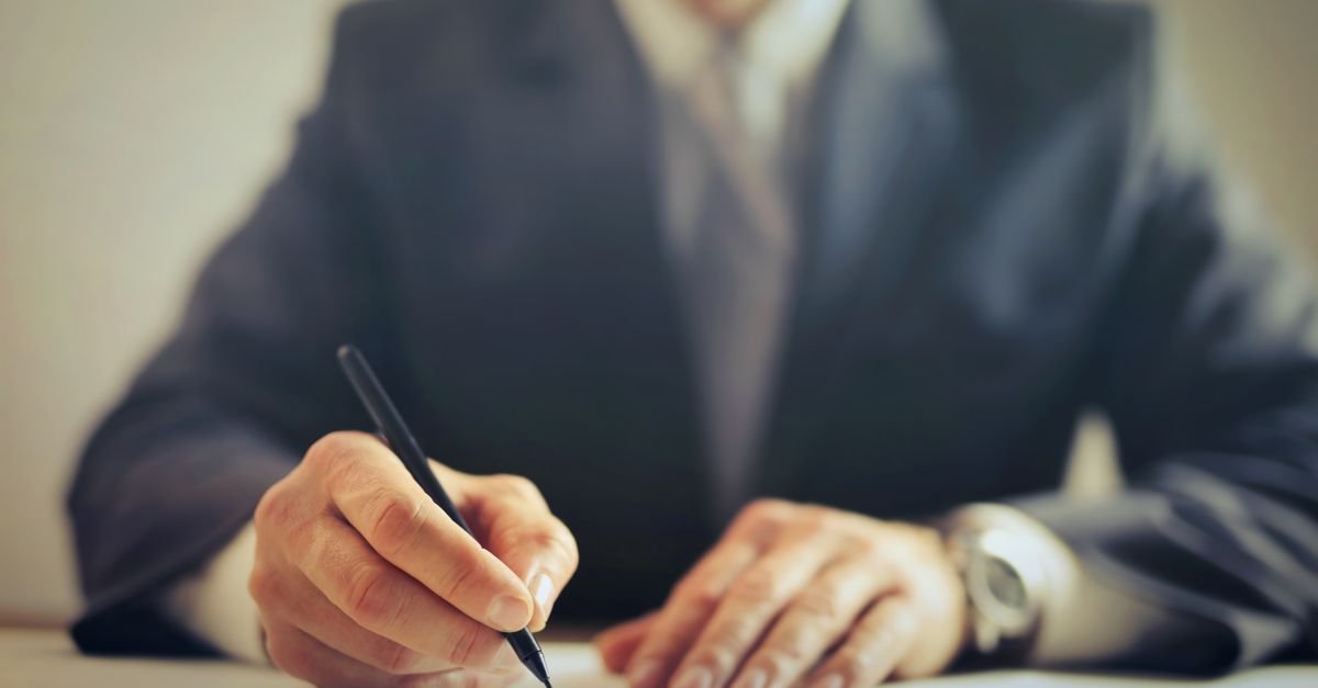 Businessman signing an office lease contract, representing IFRS 16 lease liability recognition for ICAG students