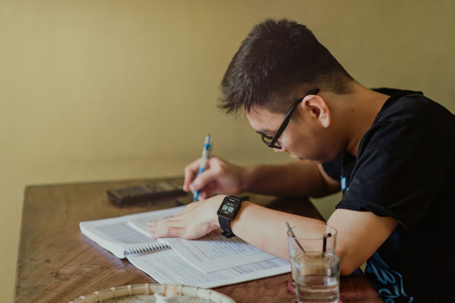 Student studying with notes and books at a desk, preparing for CITG exams