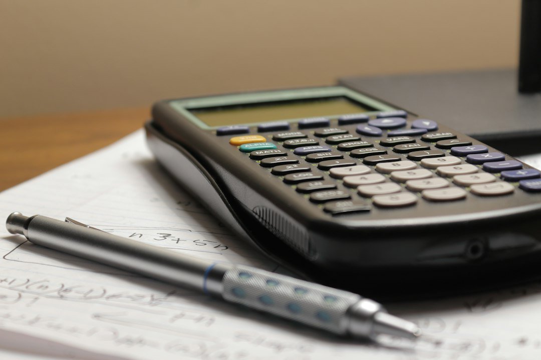 Calculator and pen on paper for ICAG accounting exam revision