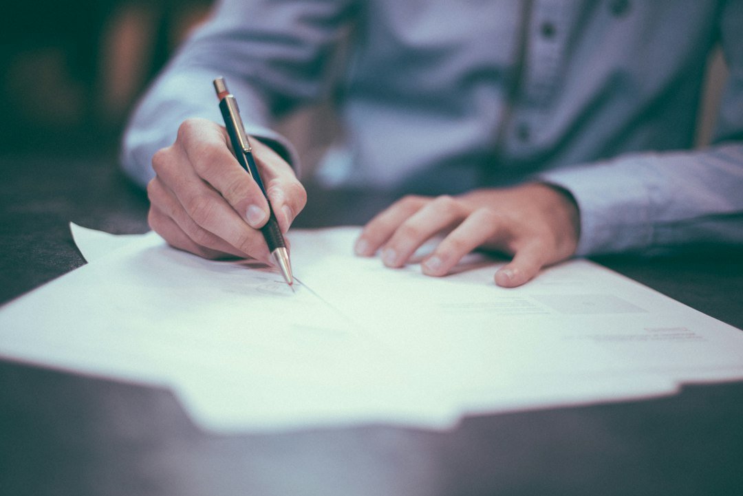 Hand signing a formal document, representing a written tax objection