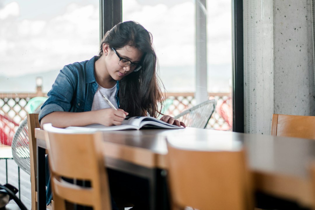 Student writing notes in a book while preparing for CITG exams